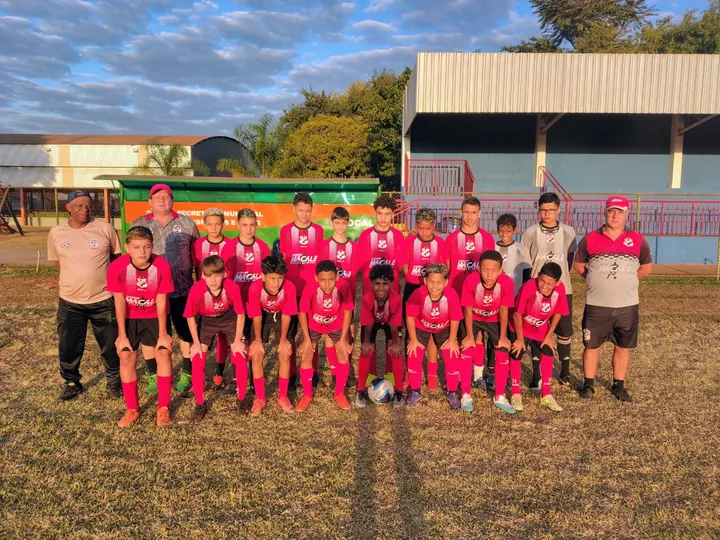 Equipe de futebol reunida para uma fotografia no campo do clube.